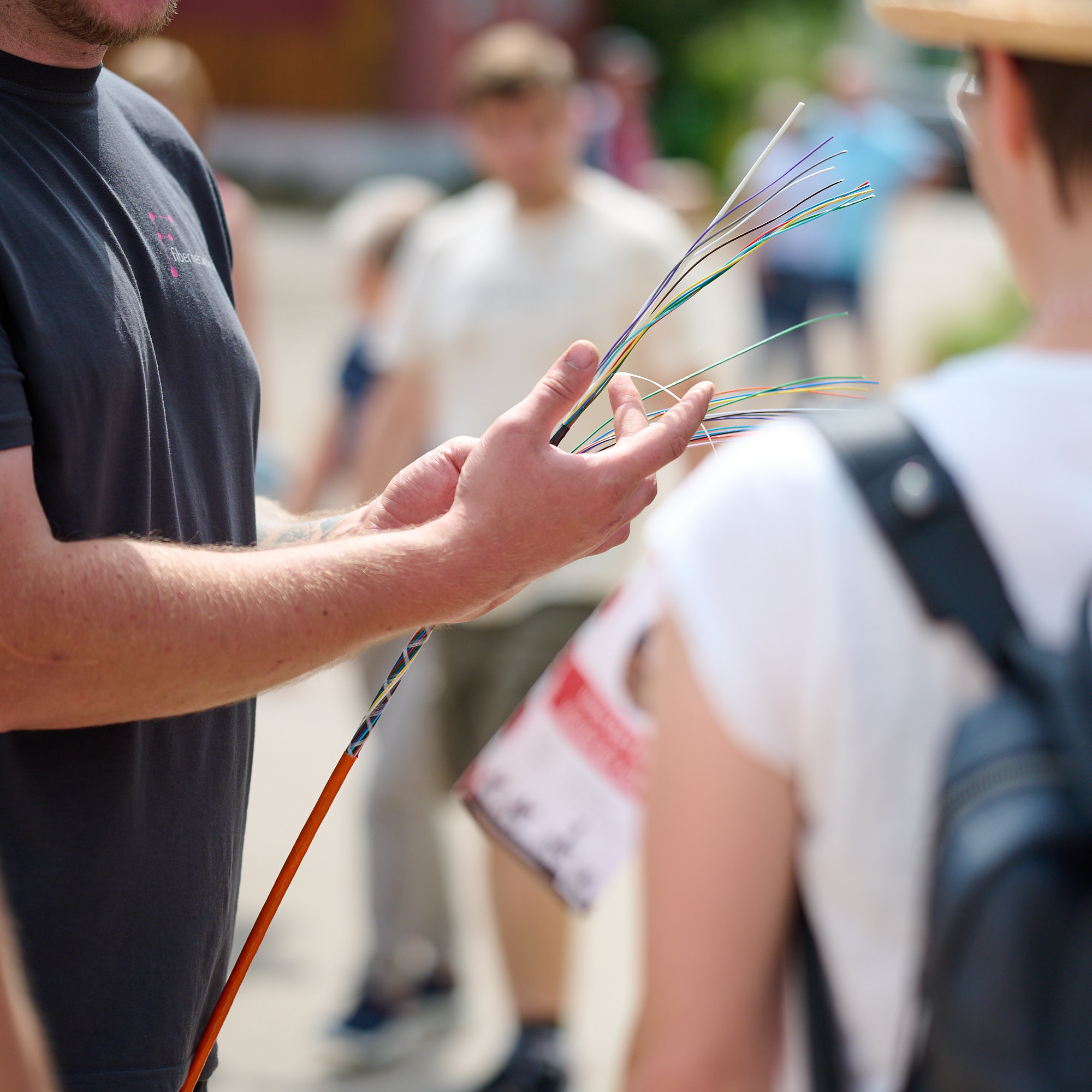 Ein Mitarbeiter der Fiber Network WUG zeigt die dünnen Glasfaserleitungen beim Flurumritt in Pfofeld 2023